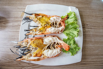 Grilled giant river prawn in white dish on wooden table,Thailand food