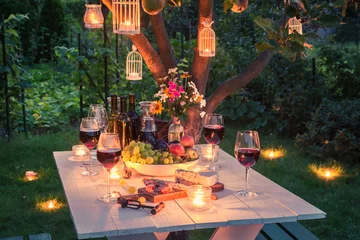Poster Mooie tafel vol kaas en vleeswaren in de tuin in de schemering? © shaiith
