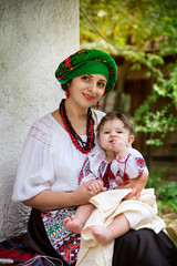 Mom in the Ukrainian suit holds a baby daughter