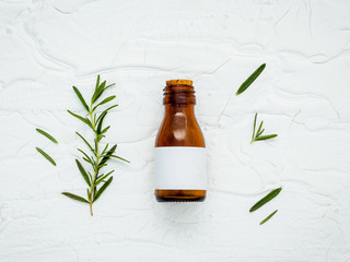 Fresh branch of rosemary  with bottle essential oil setup on whi