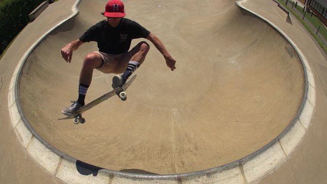 Skater airs out of a skate bowl.