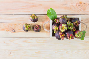 Mangosteen on wooden box, top view background.