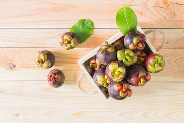 Mangosteen on wooden box, top view background.