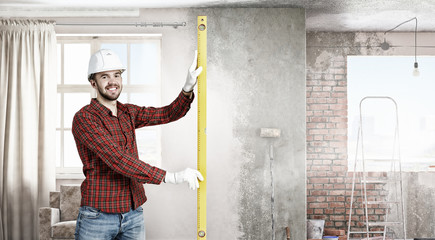 Builder checking spirit level . Mixed media