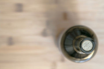 Still life with a wine bottle standing on a wooden surface blurred background, view from above.