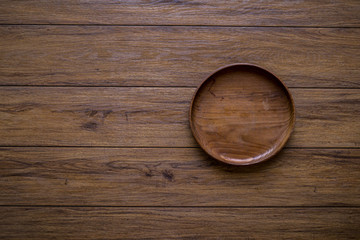 The brown wooden plate on a rustic table closeup. horizontal top