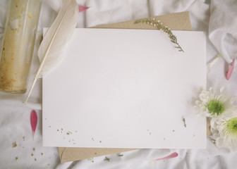 Blank white card with flowers and pen