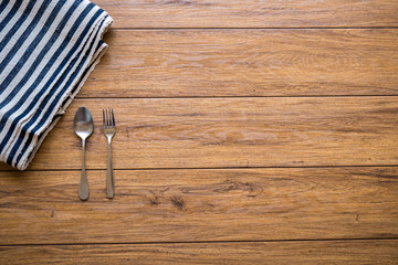 white plate and fork on old wooden table with checked tablecloth