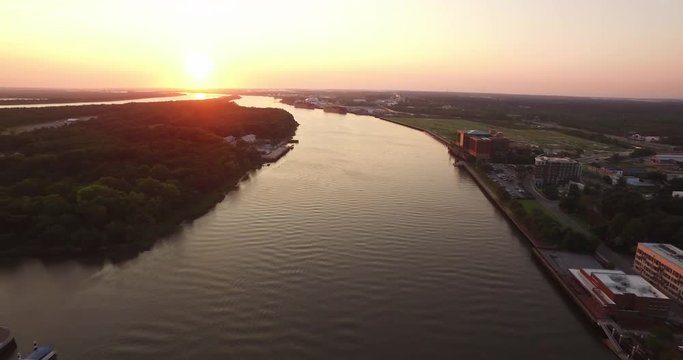 Aerial of the Savannah River at sunrise with an industrial port downriver.