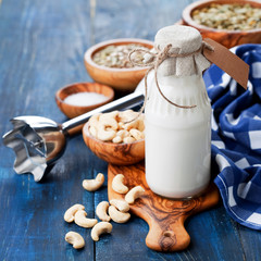 Raw vegan cashew milk in glass bottle, selective focus