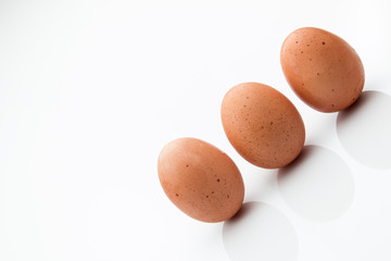 Three brown eggs isolated on a white background.