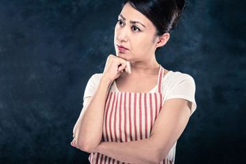 Fototapeta premium エプロンを着ている女性のポートレート 暗い背景