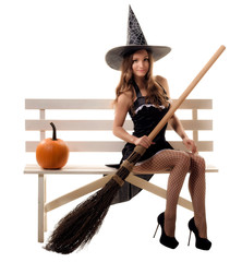 young woman in a witch costume posing in studio