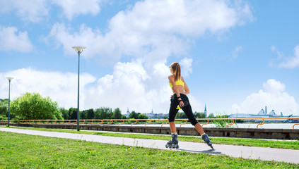 Young and sorty woman rollerskating in the park