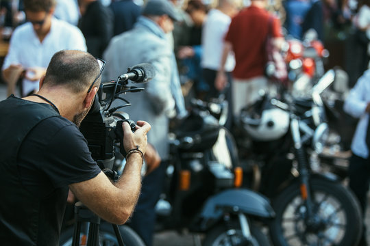 Professional man with camera at motorbike exhibition