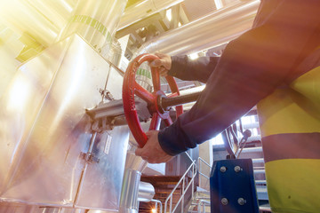 factory worker turning valve