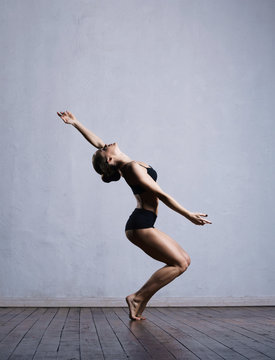 Young and fit ballerina dancer in a studio