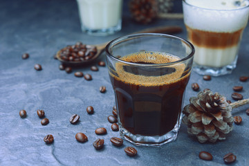 glass of hot espresso and cappuccino coffee with creamer, glass of milk and moka coffee pot on a...
