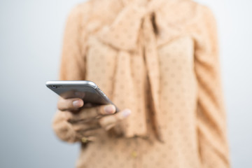 asian businesswoman using smart phone on gray background.
