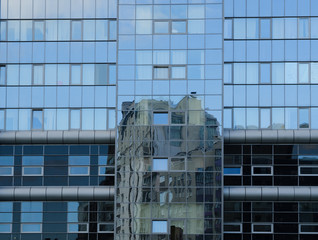Fototapeta na wymiar another building reflected in glass facade
