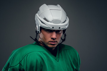 Naklejka premium Portrait of hockey player on grey background.