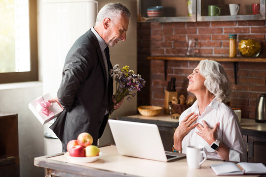 Elderly Man Giving Flowers To His Dear Wife