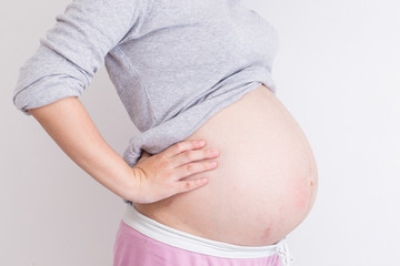 Pregnant woman has backache and touching her torso