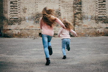 two girls with long hair running away