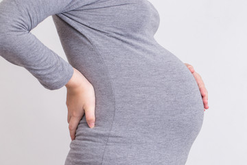 Pregnant woman has backache and touching her torso