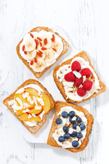 sweet toast with different toppings on white wooden board