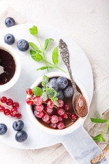 Delicious chocolate dessert with berries and mint served in ramekin. Top view. Copy space.