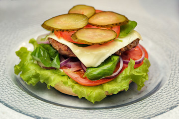 Have added slices of pickles, cheese and tomato in hamburger. Cooking burger concept