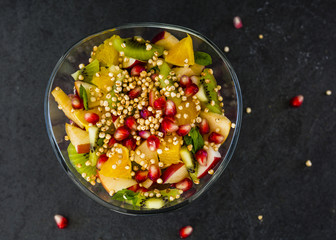 Tasty fruits salad on stone background. Healthy diet. Vegetarian food. 