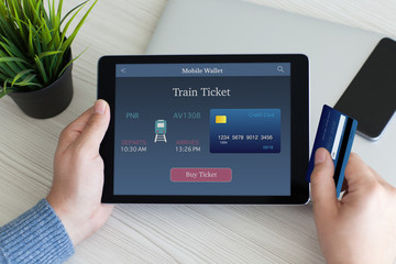 man holding tablet computer online train ticket and credit card