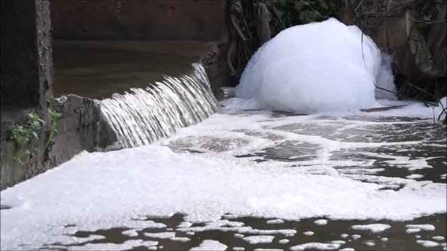 Water pollution - Waste water full of bubbles released from the industrial ares affecting natural water resources