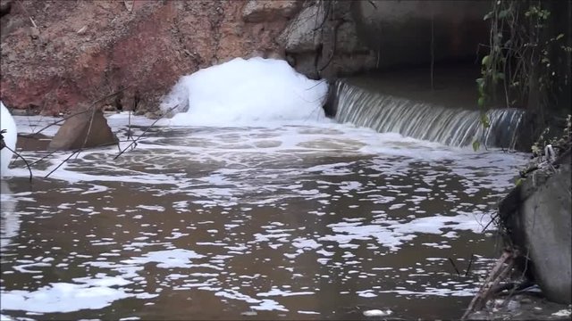 Water pollution - Waste water full of bubbles released from the industrial ares affecting natural water resources