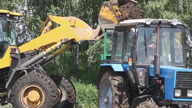 The loader loads the manure into the tractor trailer