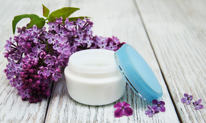 moisturizing cream and lilac flowers