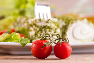 Goat cheese with salad and cherry tomatoes. 