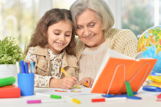 Grandmother with granddaughter drawing together