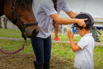 Child wearing caps to mount on horseback