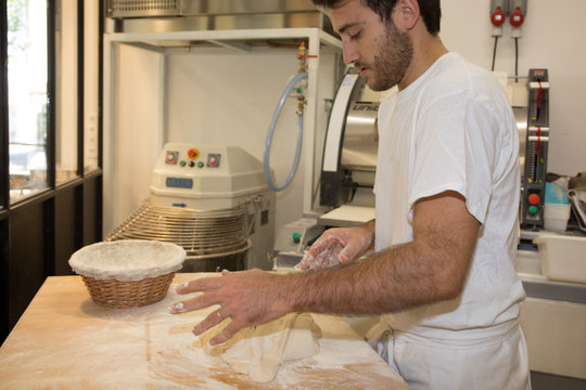 Making dough by male baker at bakery