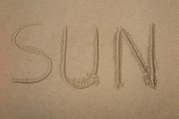 The Word Sun Written in the Sand on a Beach