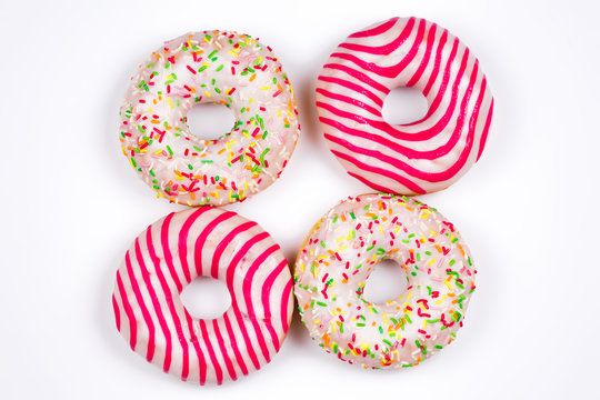 Four colorful donuts isolated on white.