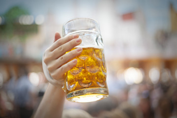 Woman's hand holding beer steins at Oktoberfest