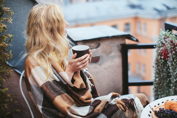 woman with tea sheltered blanket breakfast on the balcony overlooking the city