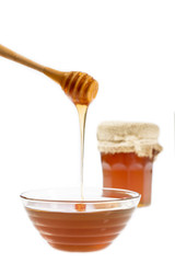 Honey flowing into glass jar