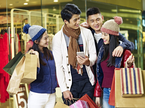 young asian couples enjoying shopping in mall