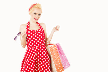 female model holding shopping bags in her arms wearing red dress