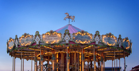 Retro carousel illuminated at night, blue hour